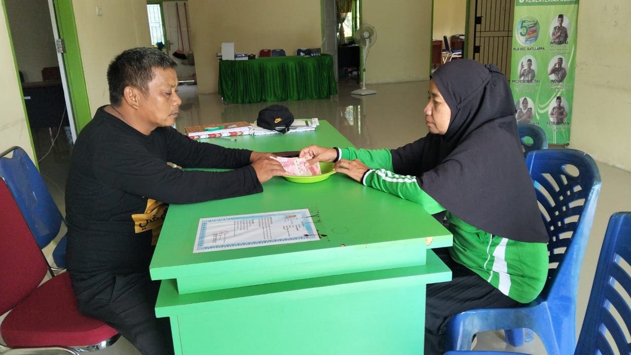 Staf KUA Batulappa, M. Amin, menerima zakat dari warga untuk disalurkan melalui BAZNAS Kabupaten Pinrang.
