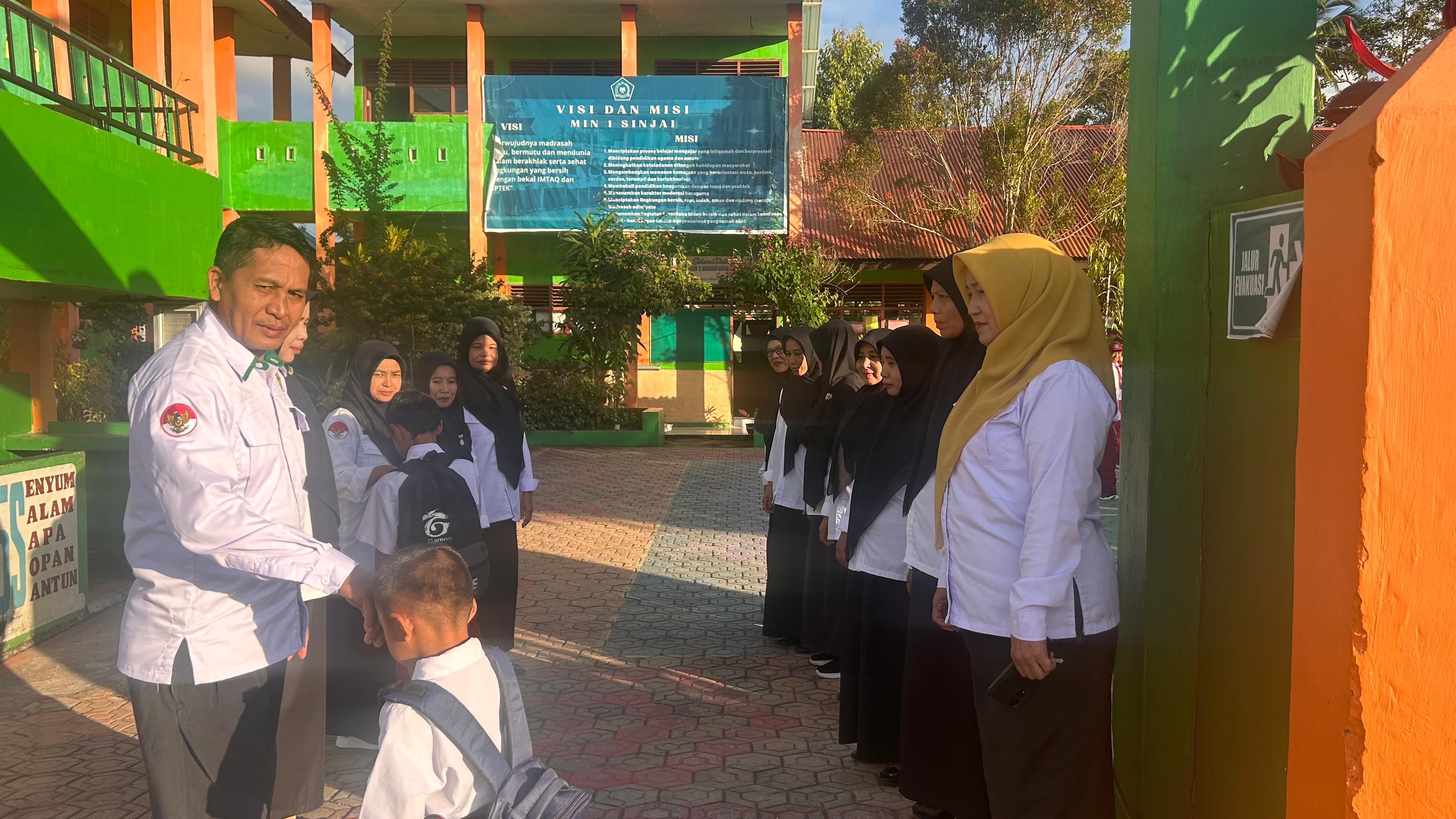 Pengawas Madrasah bersama Kepala MIN 1 Sinjai menyambut kedatangan peserta didik di gerbang madrasah