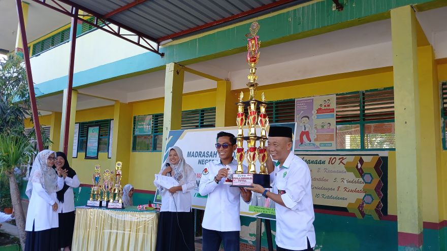 Kepala MIN 1 Bone menerima Piala Bergilir yang telah diraih Madrasahnya dalam ajang LKPPM jilid 3 tahun 2025