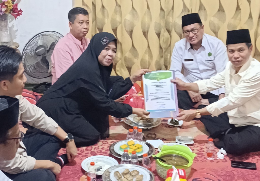 Direktur Pelayanan Haji H. Muhammad Zain menyerahkan sertifikat Badal Haji kepada istri almarhum Rachmat Selamet, di Maros. (foto:ist)
