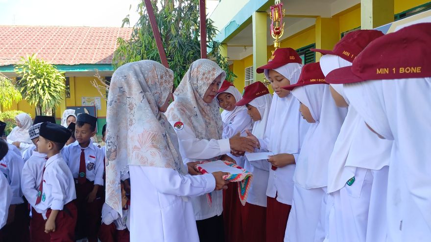 Pendidik MIN 1 Bone menyerahkan apresiasi untuk peserta didiknya yang telah berjuang dalam ajang LKPPM jilid 3 tahun 2025
