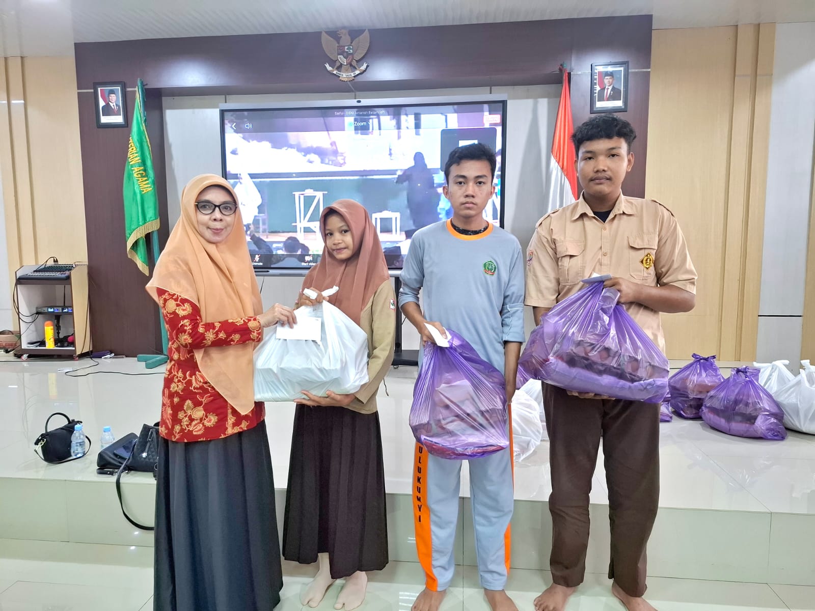 Ketua DWP Kemenag Takalar Hj. Insana Malik Solihin saat menyerahkan paket santunan kepada siswa Yatim piatu