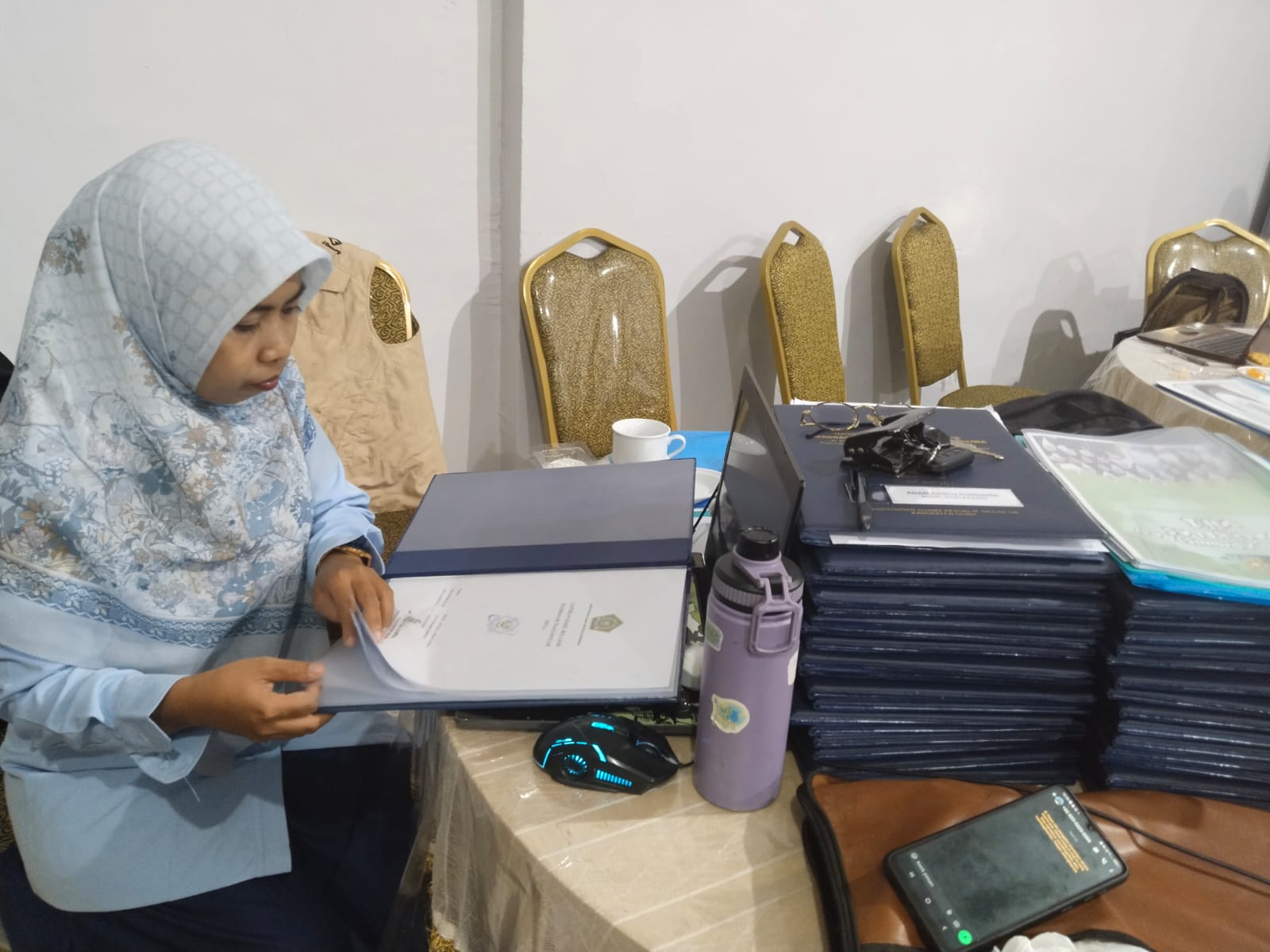 Salah seorang guru saat memeriksa raport